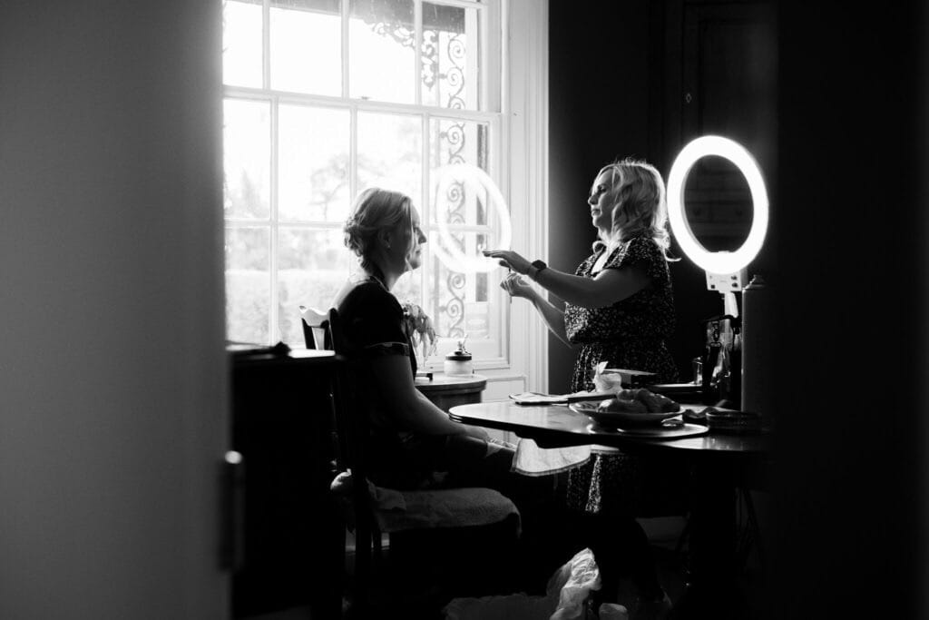 bride getting ready for her wedding day black and white image with make up artist
