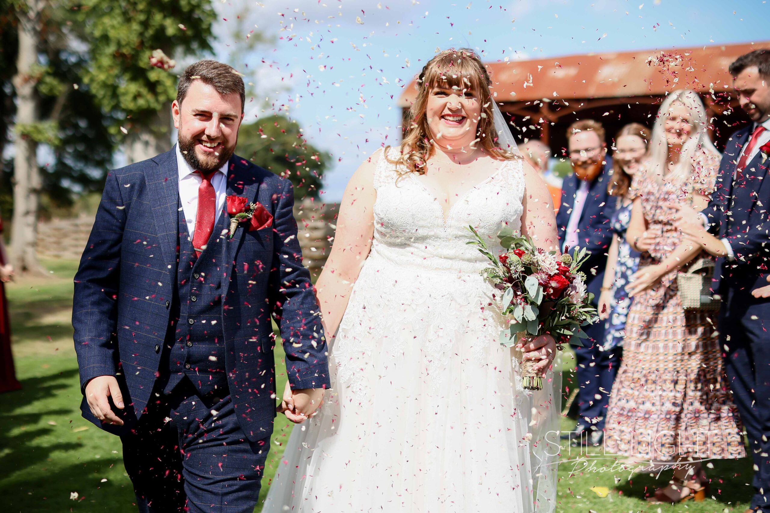 bride and groom walking under confetti throw during barns and yard wedding video