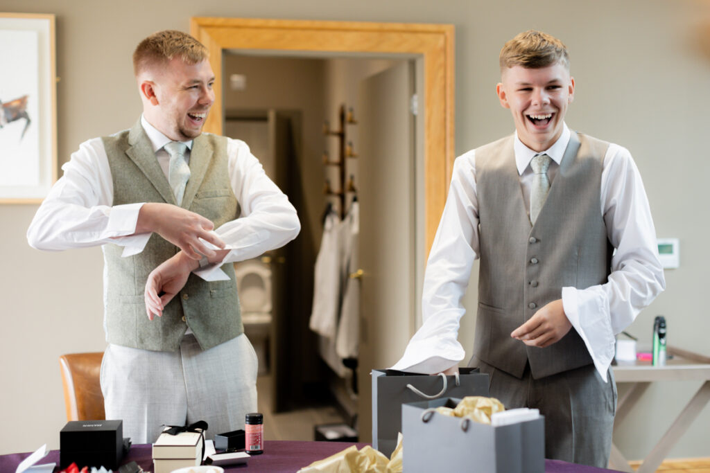 groom and friend laughing getting ready at Arley House & Gardens
