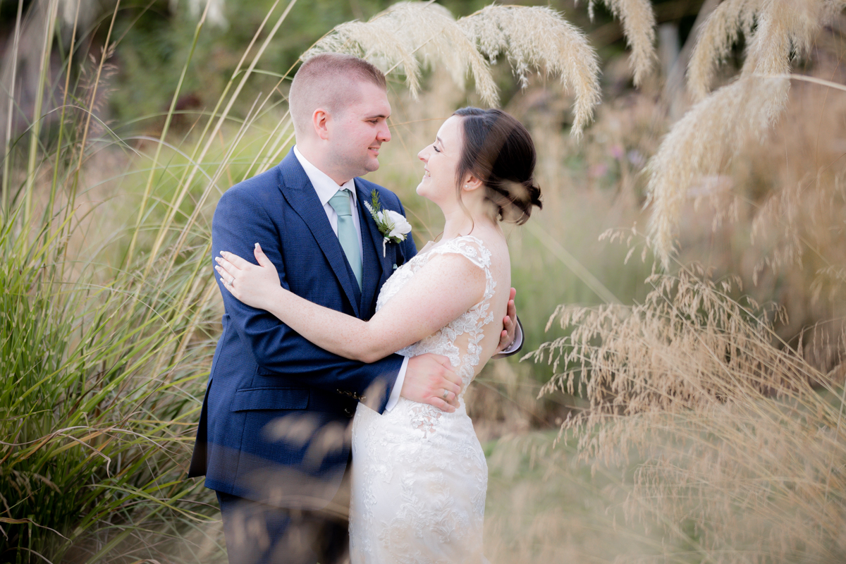 couple embracing in arboretum photographed by Arley House and Gardens Wedding Photographer