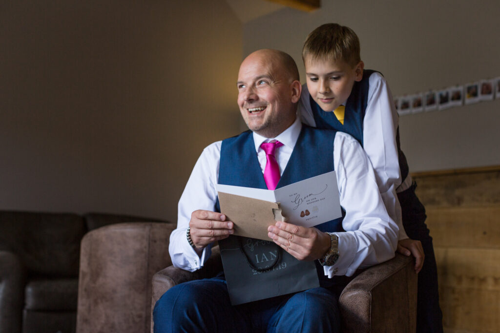 groom reading card from bride as his son looks over his shoulder