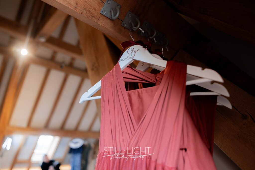 burnt orange bridesmaids dress hanging up at redhouse barn