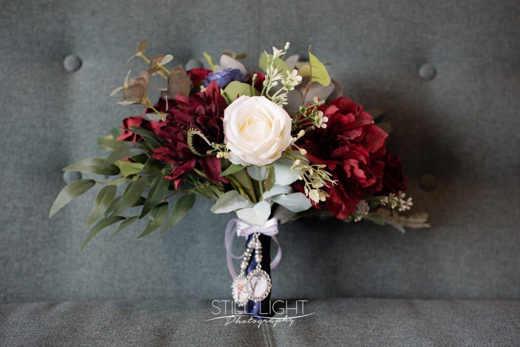 bride's wedding bouquet of flowers with reds and navy blue