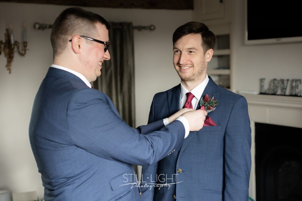 groom getting ready for wedding day in the farmhouse at wotton park