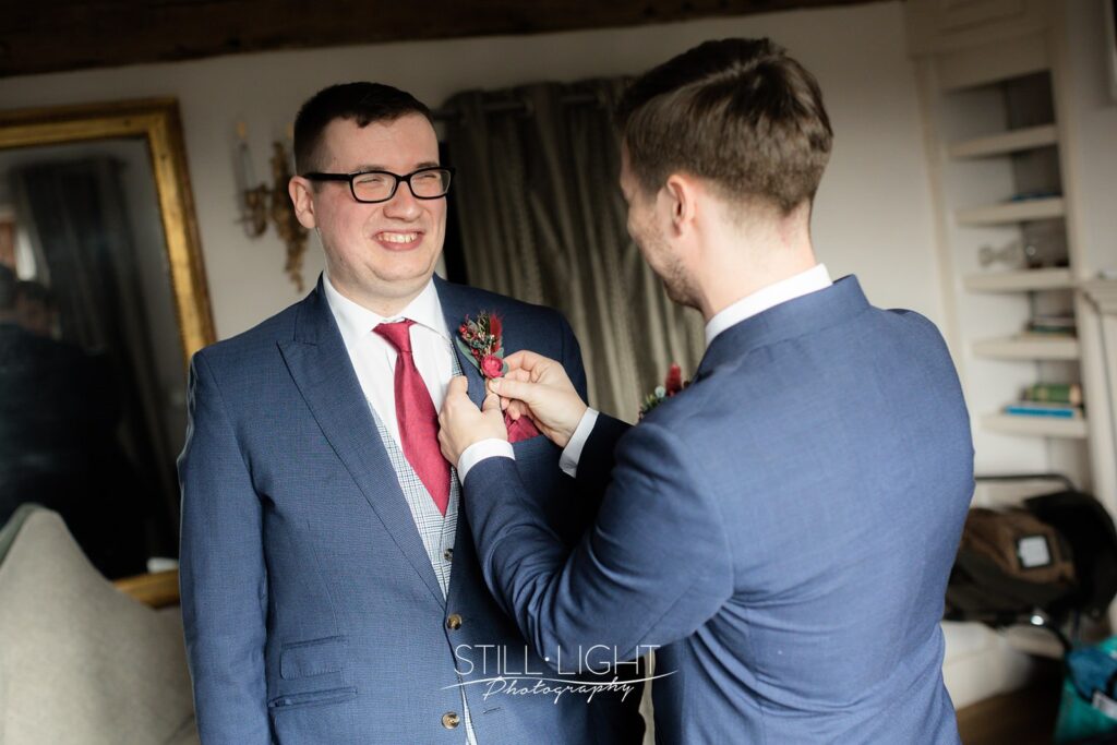 groom getting ready for wedding day in the farmhouse at wotton park