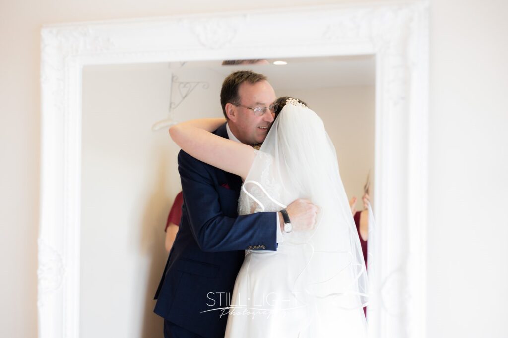 bride hugging her dad during bride's reveal to her dad on wedding morning at wootton park