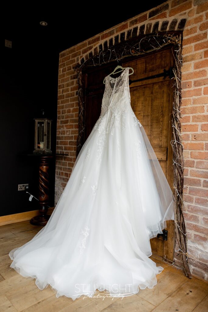 brides dress hanging on door at redhouse barn
