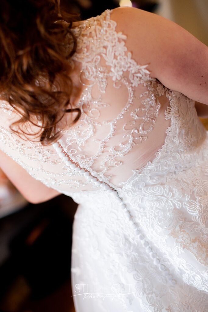 bride on her wedding day at redhouse barn wearing dress with lace and beading