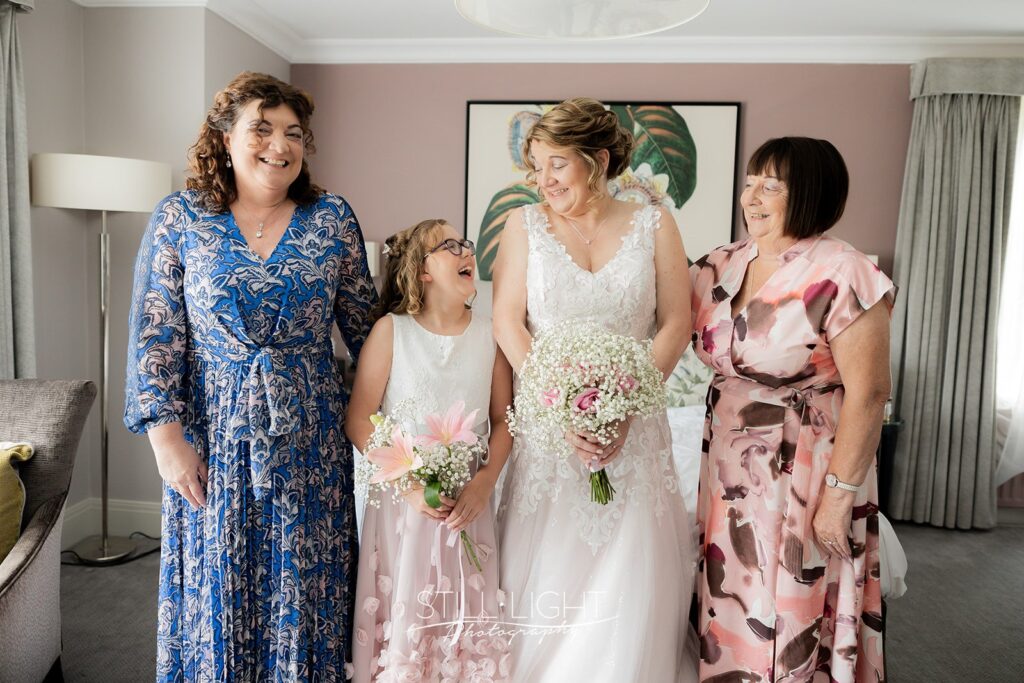 bride and 3 ladies laughing together getting ready for their ceremony