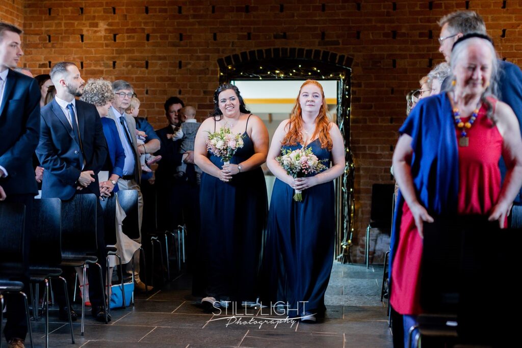 bridesmaids entering ceremony room red brick barn at redhouse barn
