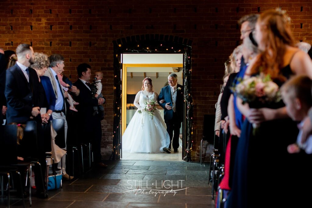 bride entering ceremony room red brick barn at redhouse barn