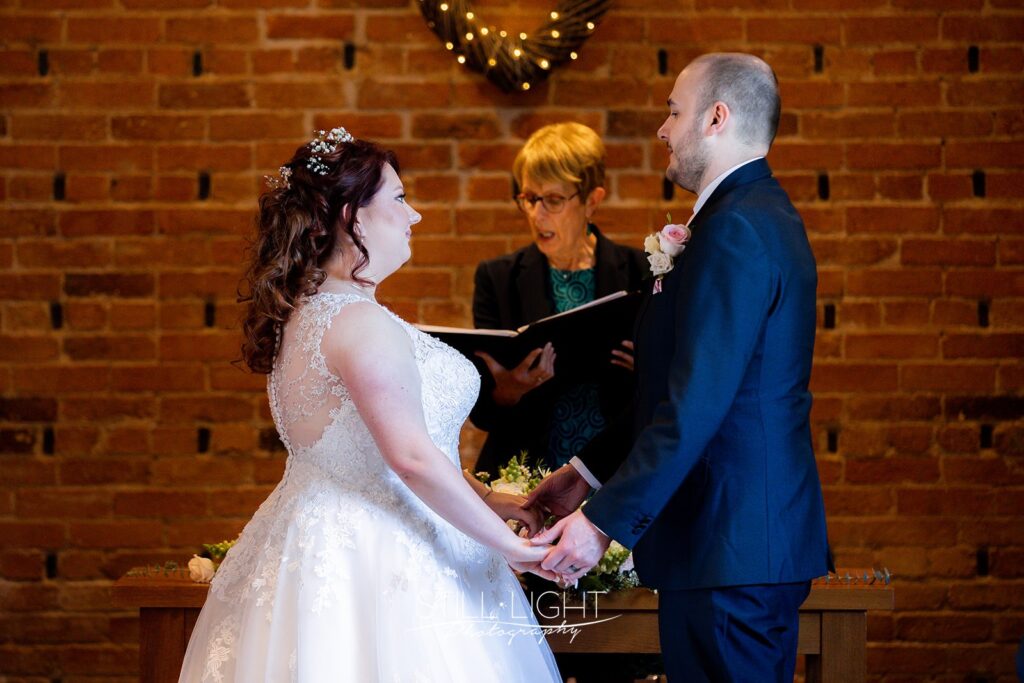 bride and groom standing together during wedding ceremony at redhouse barn