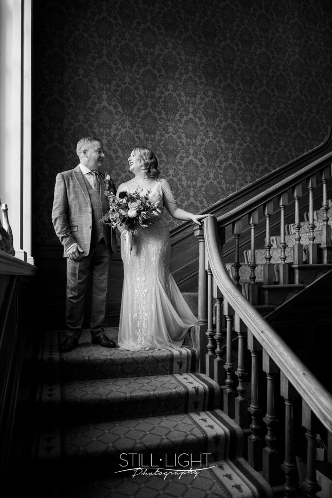 bride and her dad on staircase at brockencote hall on vintage wedding day