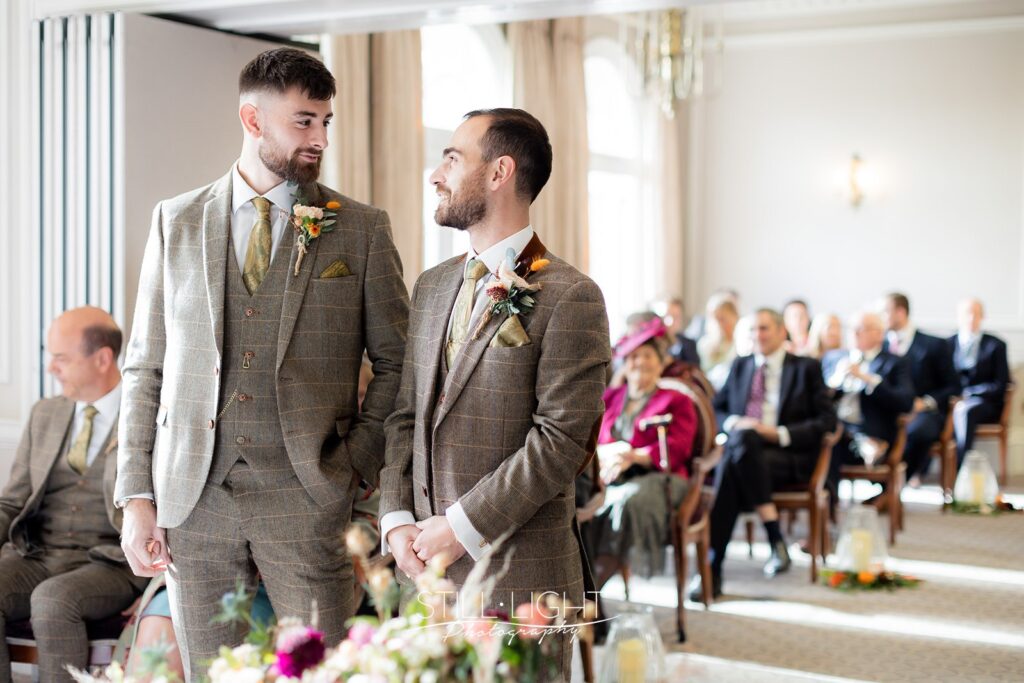 groom and best man standing at front of aisle at brockcote hall on wedding day