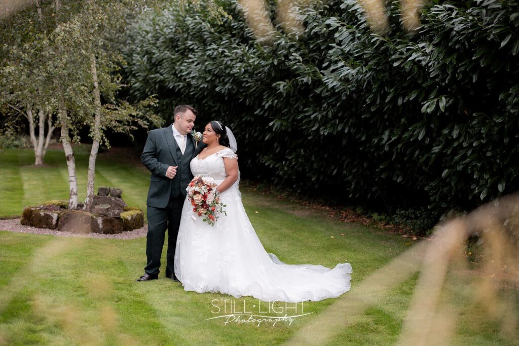 bride and groom standing together in gardens at redhouse barn