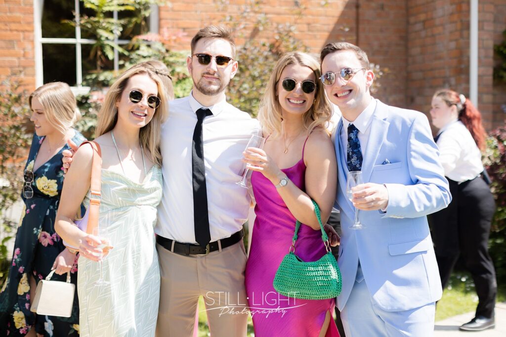 wedding guests enjoying drinks outside on a hot summer wedding day at stanbrook abbey