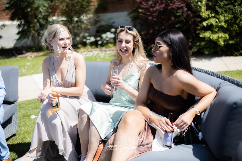 wedding guests enjoying drinks outside on a hot summer wedding day at stanbrook abbey
