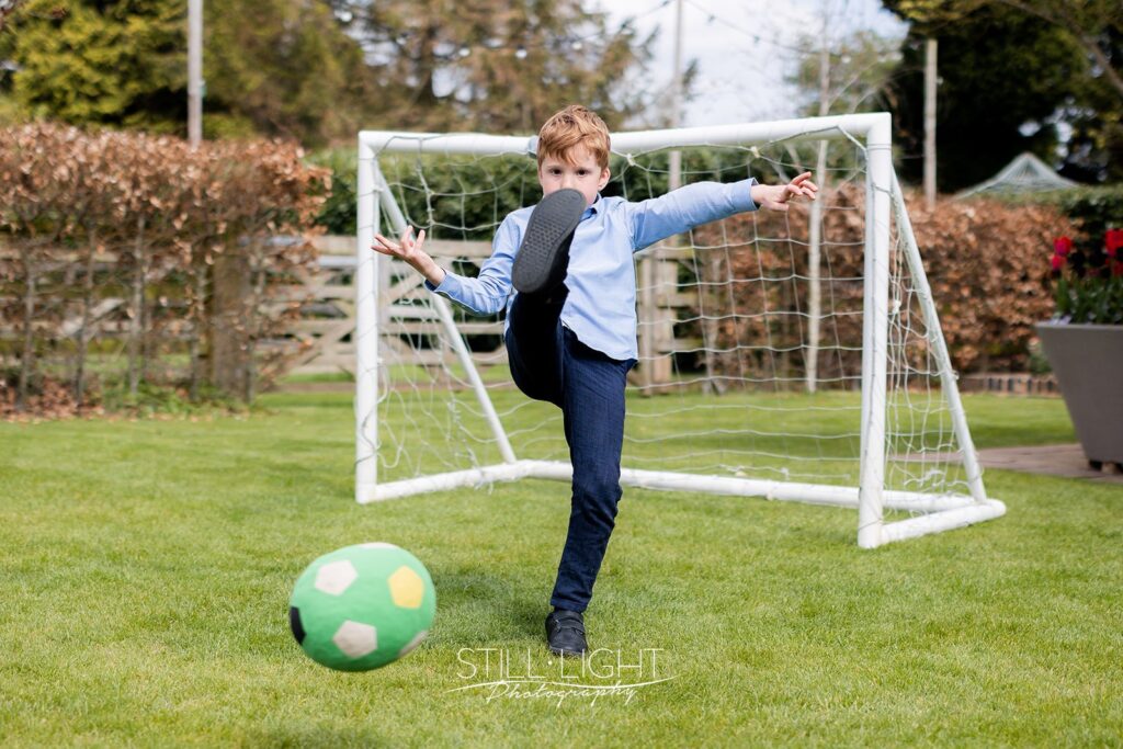 boy kicking football at camera