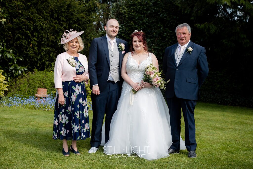 group photograph during weding at redhouse barn with gardens in background