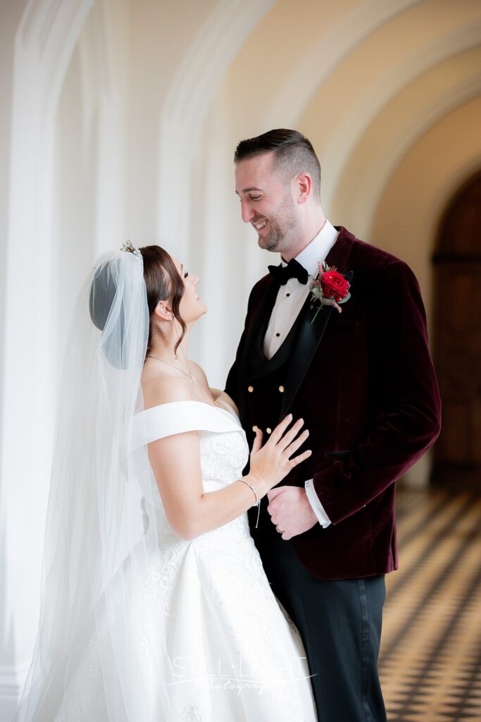 bride and groom looking at camera in photograph taken in the cloisters at stanbrook abbey hotel