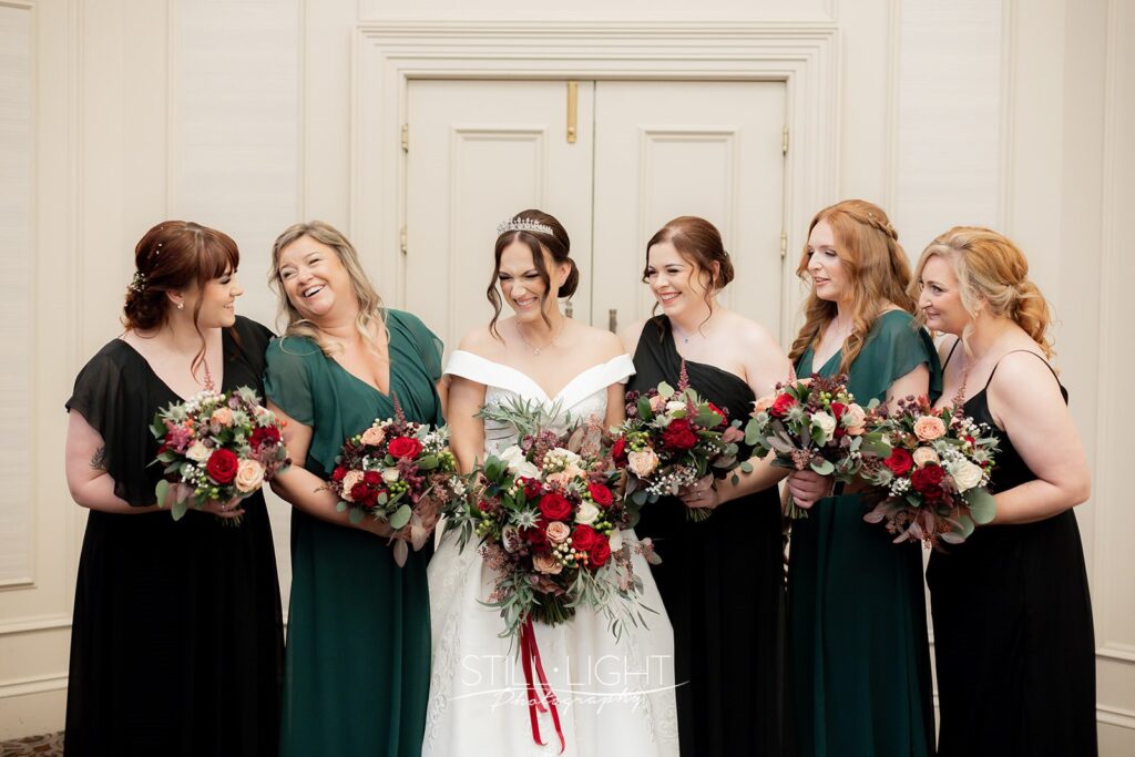 bride and bridesmaids laughing together in st annes at stanbrook abbey drinks reception