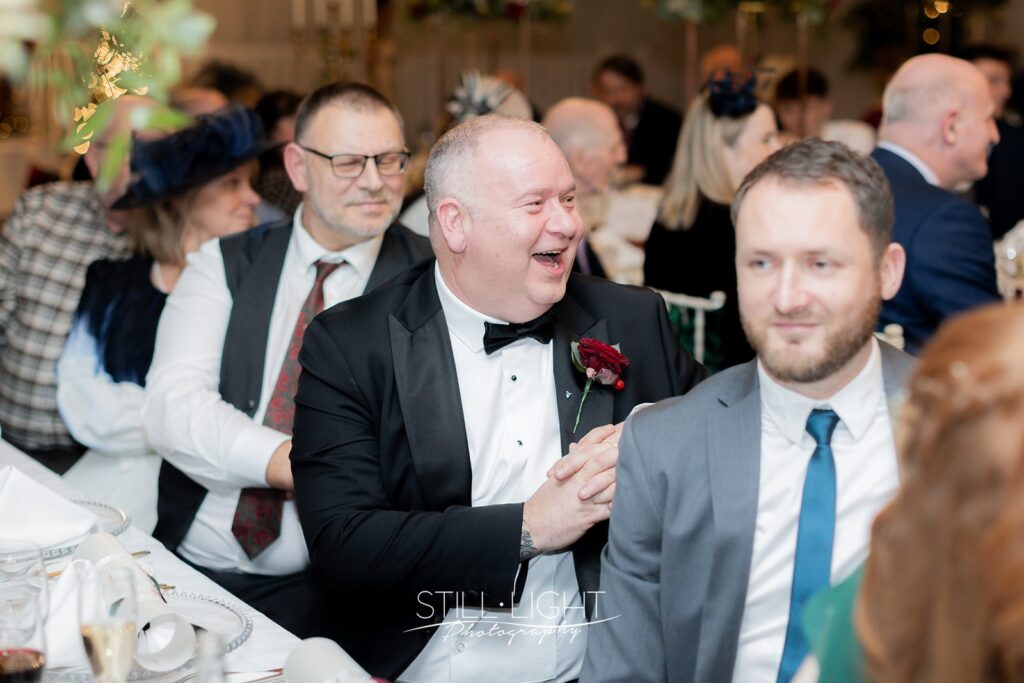 wedidng guests clapping at speeches during wedding breakfast at stanbrook abbey hotel