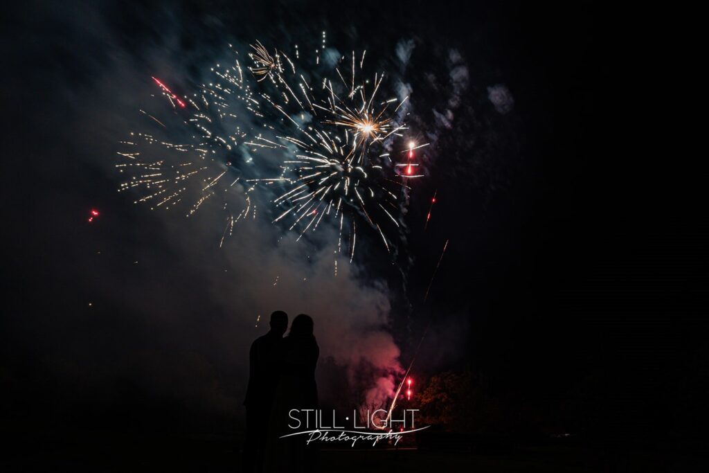 silouhette of bride and groom watching fireworks on their bonfire night wedding at wootton park