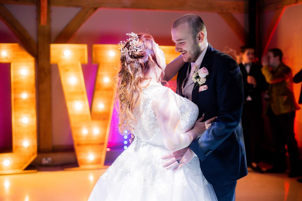 bride and groom having their first dance on dancefloor at redhouse barn