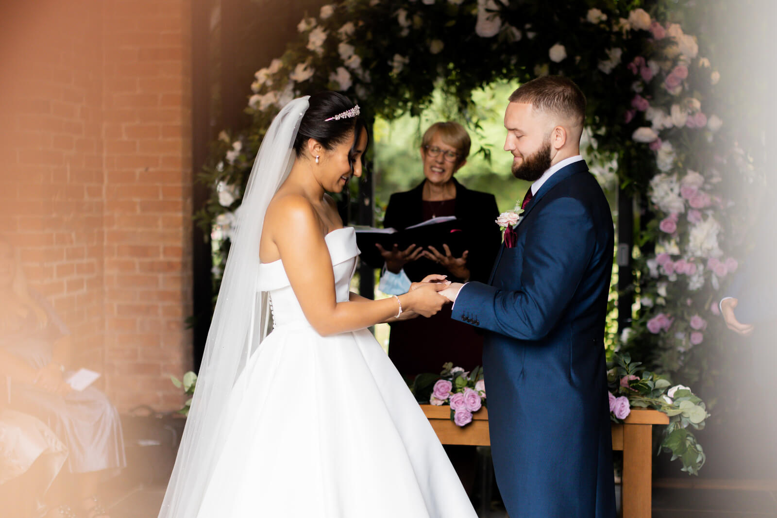 couple exchanging rings during wedding ceremony at redhouse barn