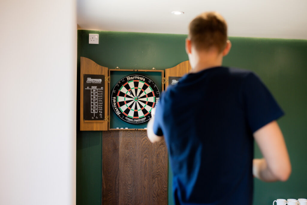 groomsmen playing darts in groom's space at wootton park