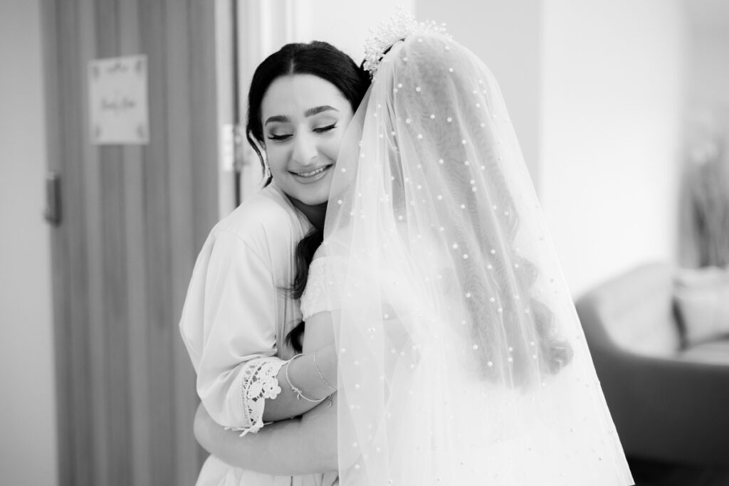 bride and sister hugging during bride reveal on wedding day at wootton park