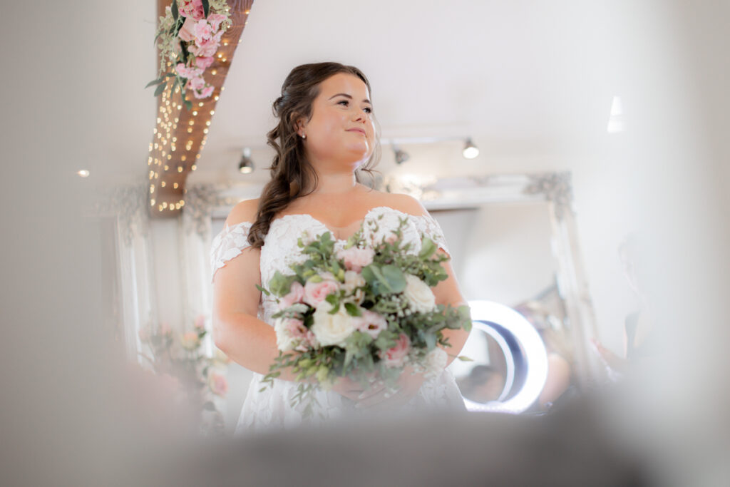 bride standing holding bouquet of flowers ready for her wedding ceremony at bordesley park
