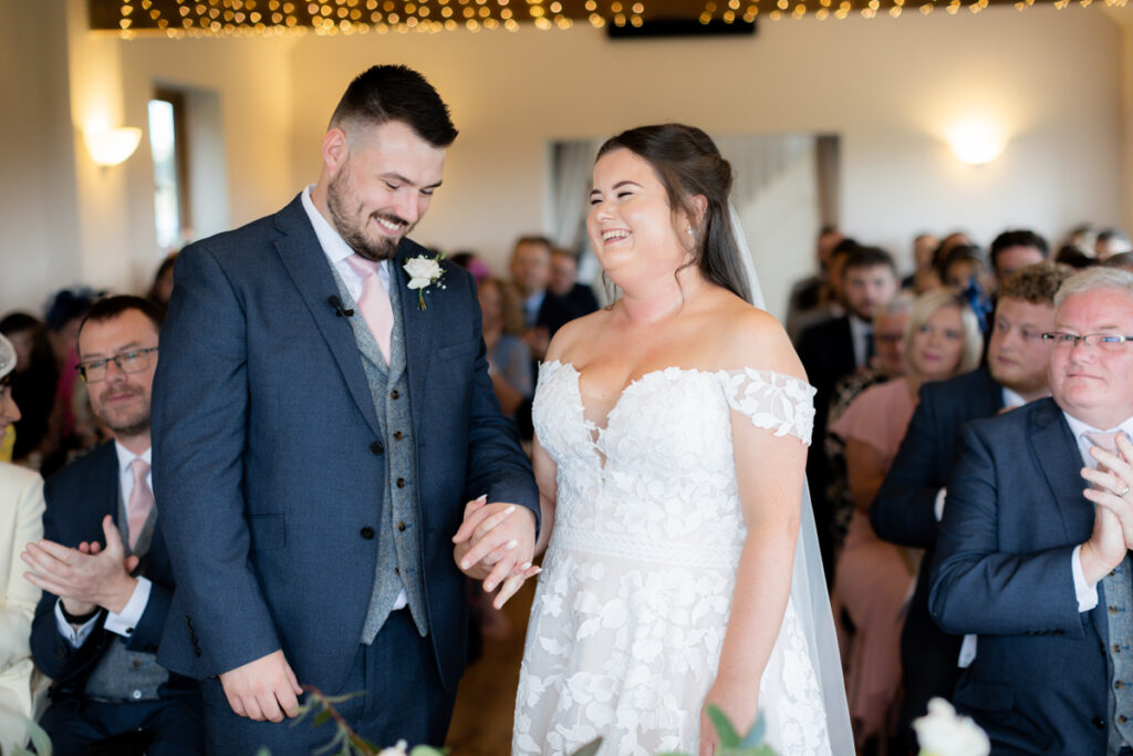 bride and groom laughing at the front of the ceremony room on bordesley park summer wedding day