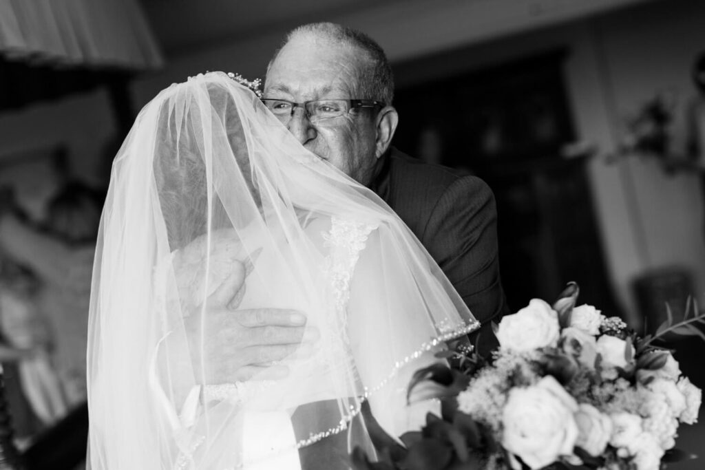 emotional father embraacing his daughter on her wedding morning, black and white photograph  by experienced wedding photographers still light photography