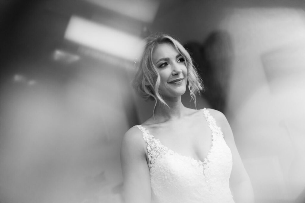 bride gettign ready for her wedding image taken throguh champagne glass by experienced wedding photographer