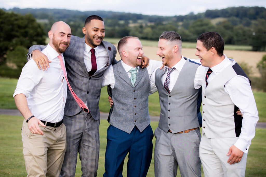 five men hugging and lauhging on wedding day at bordesley park