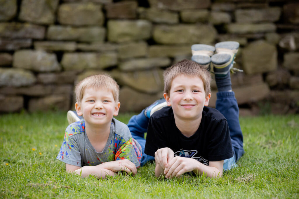 two boys lying on floor during an outdoor family photography session in worcestershire