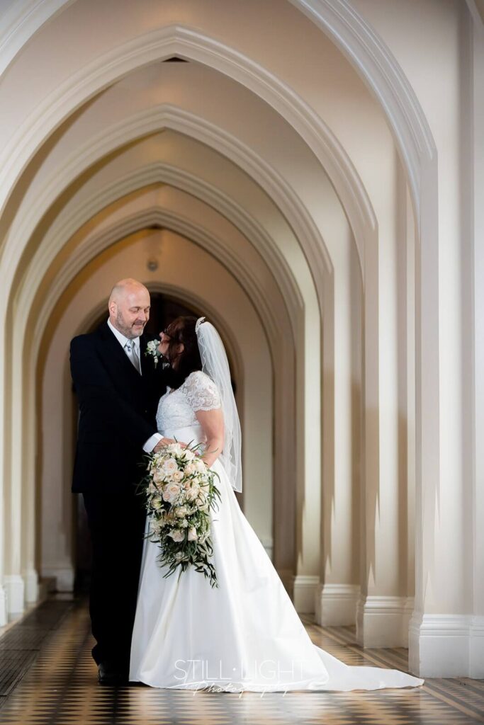bride and groom looking at each other in corridor at stanbrook abbey
