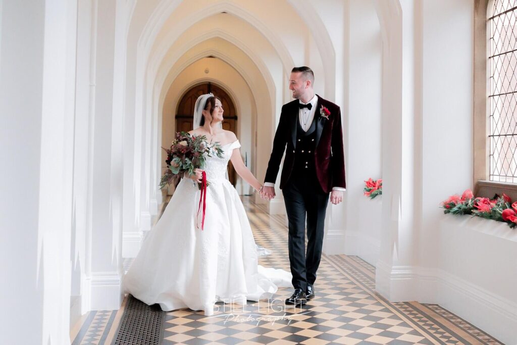 bride and groom walking hand in hand indoor in cloisters at stanbrook abbey