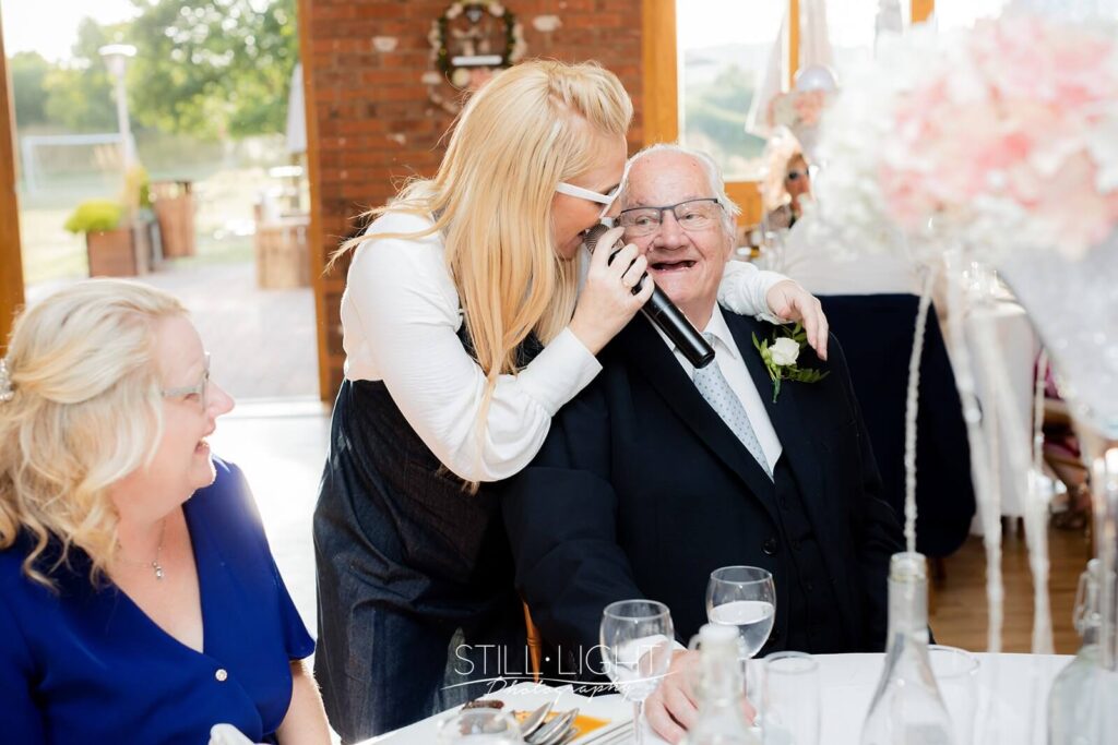 guests sing along to singing waiters during wedding breakfast at wootton park