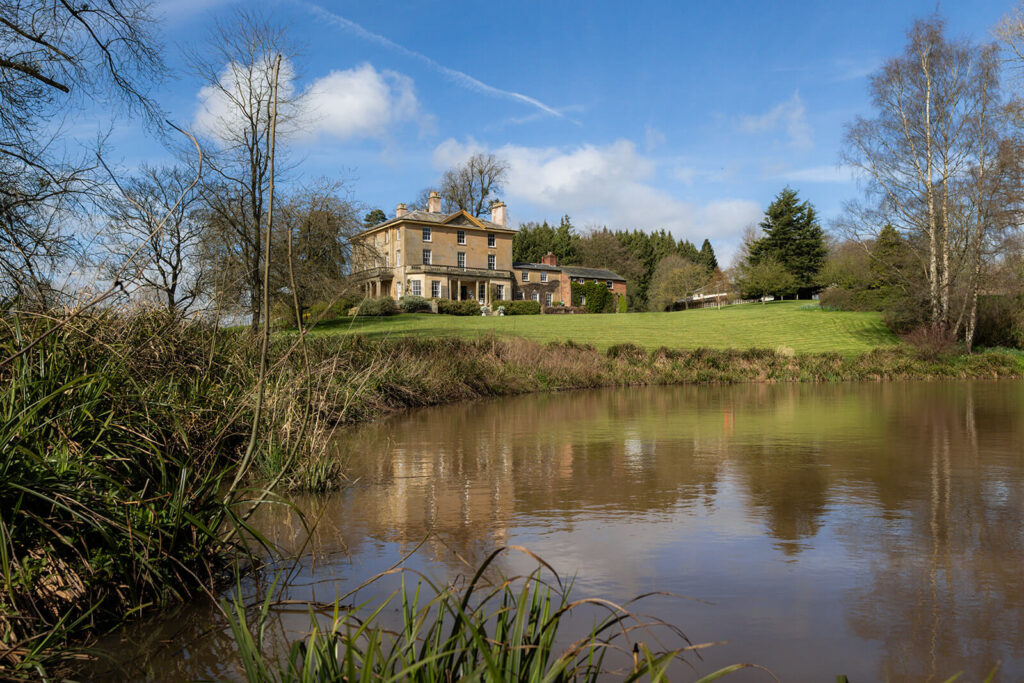 Hopton Court Manor House with lake in foreground, a dog friendly wedding venue
