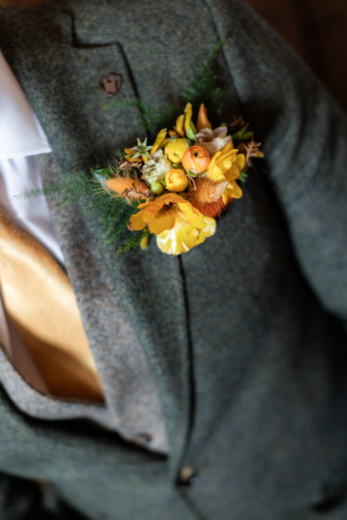 yellow and orange flowers on green tweed wedding suit